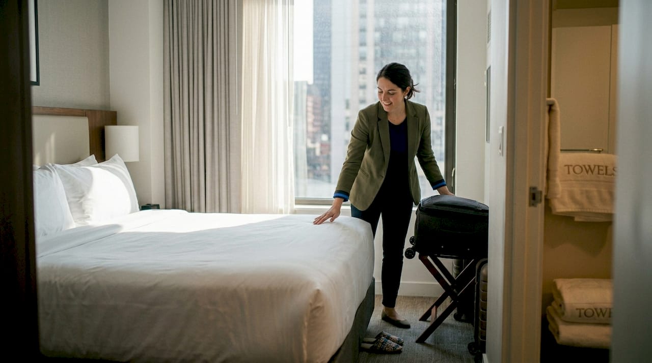 Guest touching hotel bed with custom linens