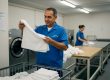 Hotel staff inspecting linens in laundry room