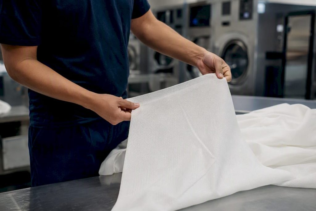 Hands stretching hotel textile fabric sample