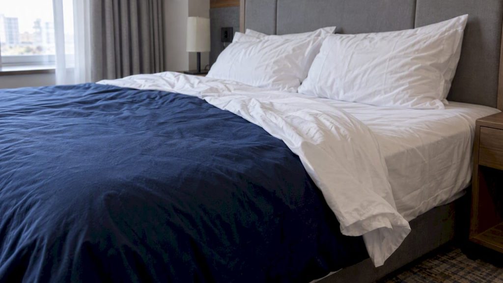 Hotel bed showing sheet and duvet cover layers