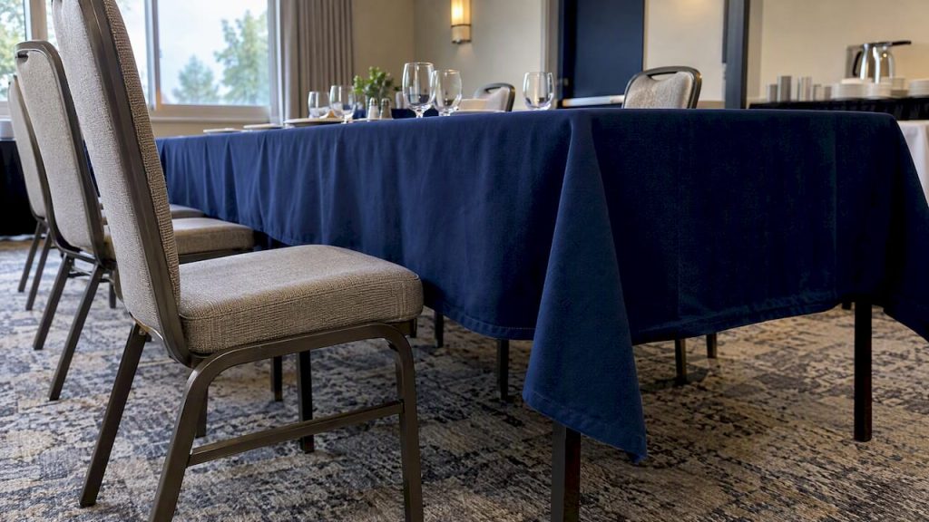 Navy tablecloth hanging beside a dining chair